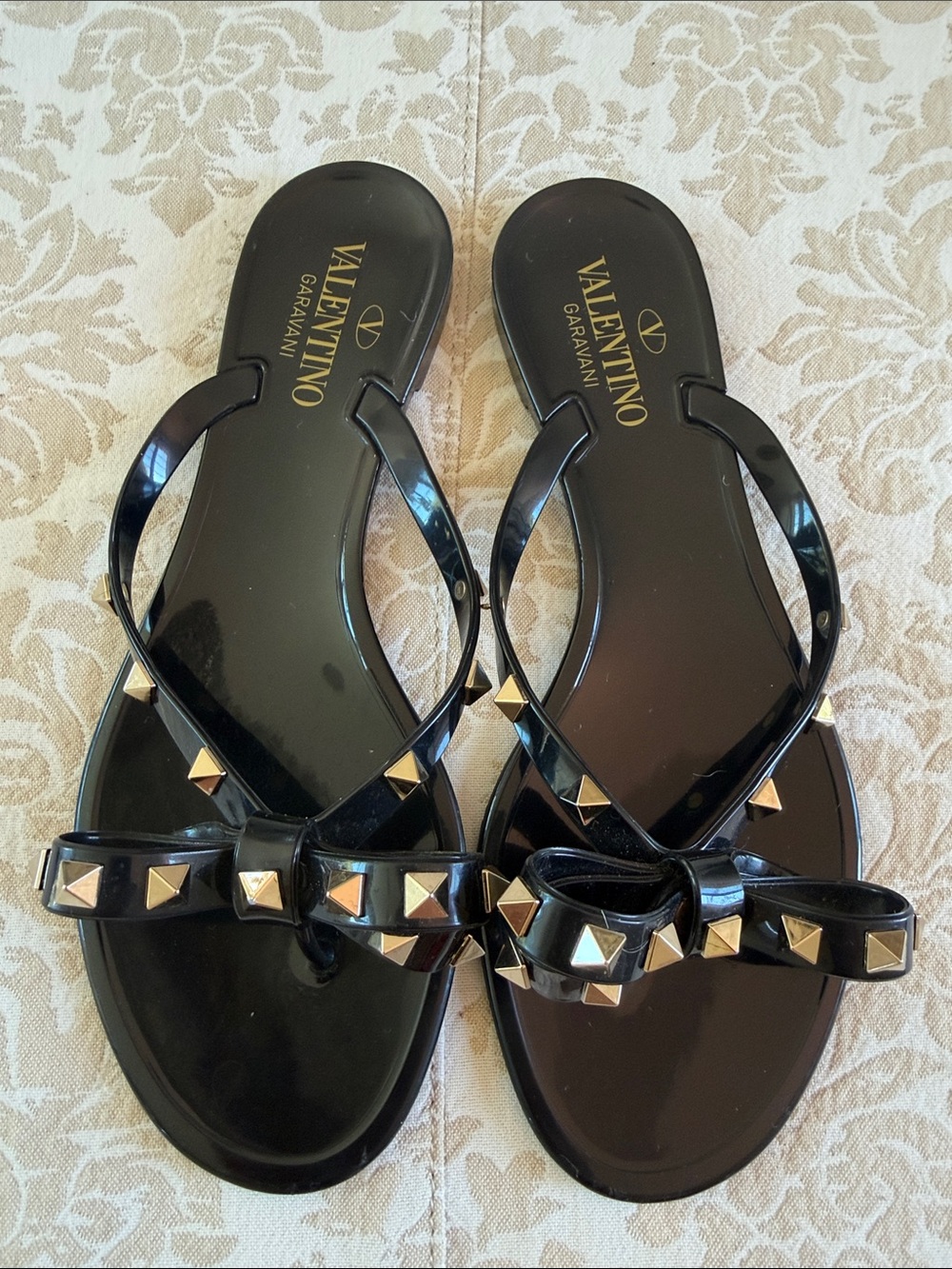 Valentino Garavani Black Jelly Sandals with Gold Pyramid Studs and Bow